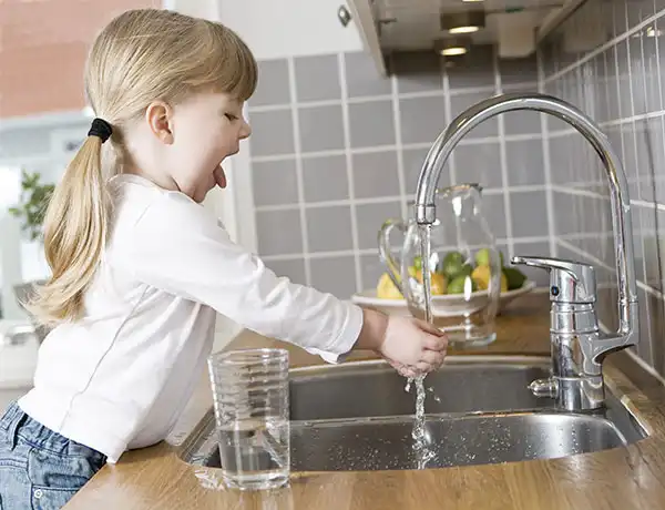 Lapsi pesee käsiään keittiön hanassa